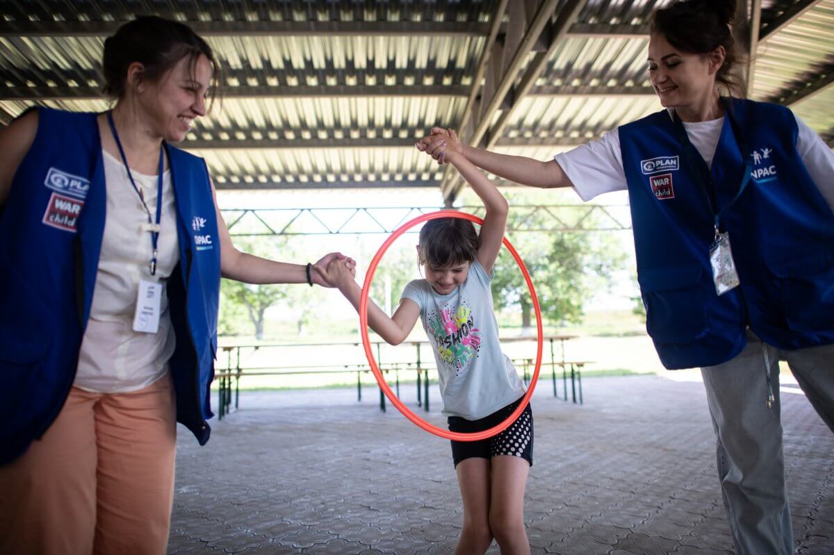 Helfer spielen mit einem Kind